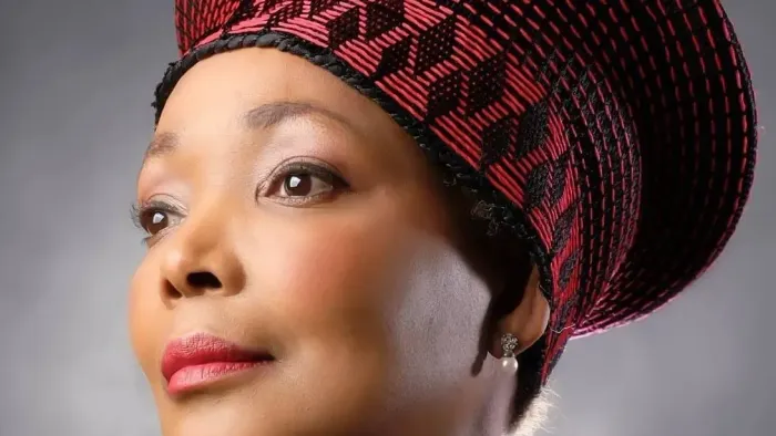 En kvinde med et rødt og sort mønstret hovedtørklæde.