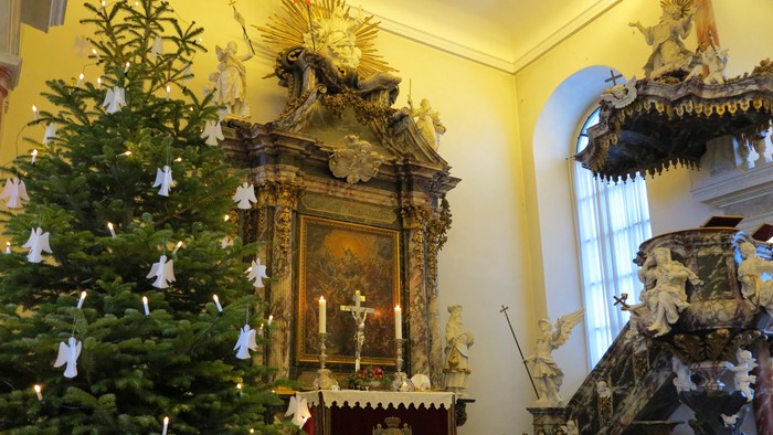 Kirkeinteriør med juletræ og alter.