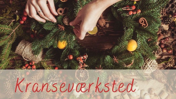 Hænder dekorerer julekrans med frugter og nødder