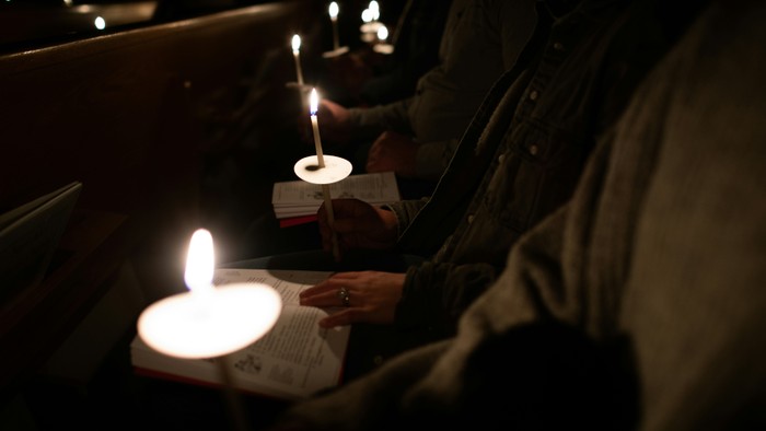 Menschen lesen bei Kerzenlicht in einer dunklen Umgebung