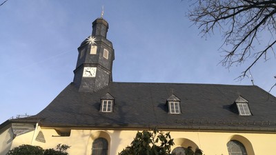 Kirche mit Uhrturm und Bogenfenstern.