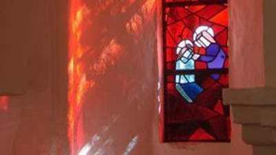 Et farverigt glassvindue i en kirke med scener fra Bibelen