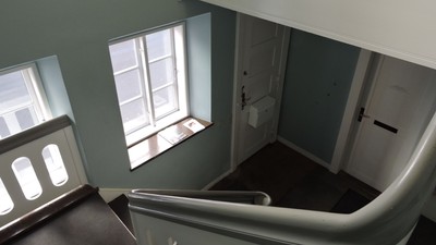 En række tømrer i et tomt værelse med et vindue og en dør.