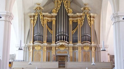 Prachtvolle Kirchenorgel mit goldenen Verzierungen in einem großen Kirchenraum