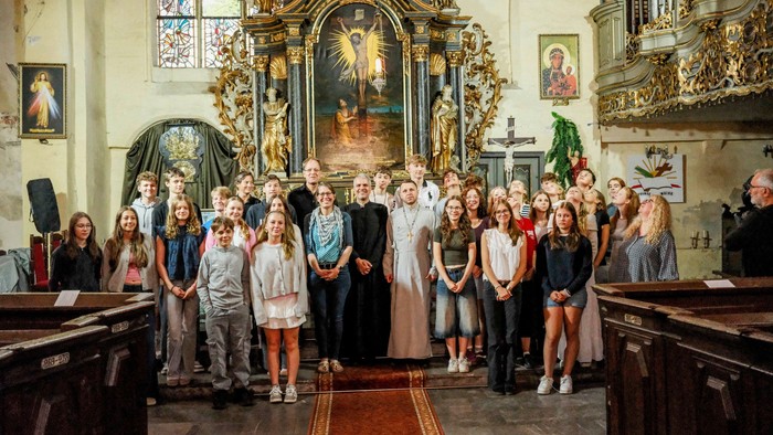 Eine Gruppe von Menschen posiert vor einem Altar in einer Kirche.