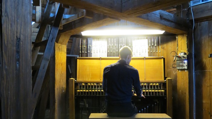 En mand sidder ved et bord i en hal.