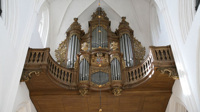 Orgelet på kirken med udsmukkede detaljer og guldakcentuer