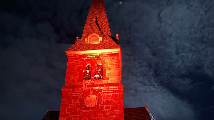 Kirche, die nachts mit rotem Licht beleuchtet wird.