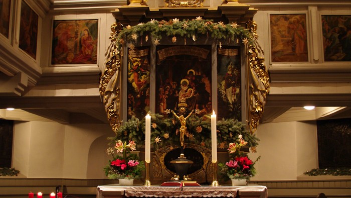 Prachtvoller Altar in einer Kirche mit Orgel und Blumenarrangements