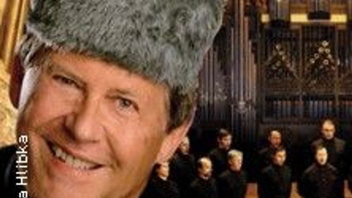 Ein Mann mit traditioneller Kopfbedeckung steht vor einem Chor in einer Kirche.