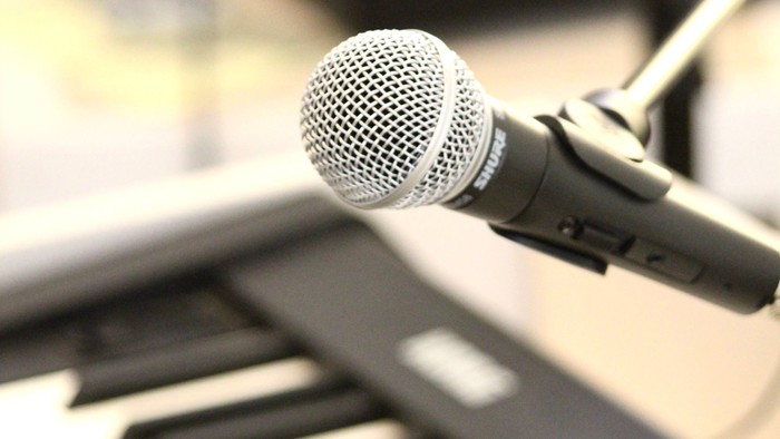 Ein Mikrofon steht vor einem Keyboard.