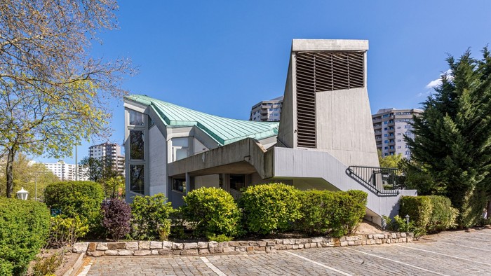 Moderne Kirche mit grünem Dach in städtischer Umgebung