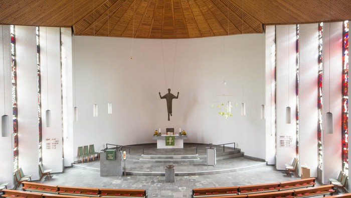 Leere Kirche mit Holzbanken und Kreuzigungsdarstellung