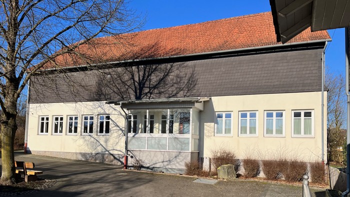 Großes Haus mit vielen Fenstern und einem roten Dach.