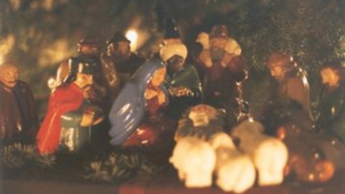 Eine Gruppe von Menschen sitzt um ein Lagerfeuer und scheint zu feiern.