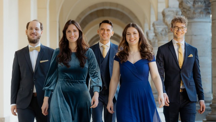 Fünf gut gekleidete Personen gehen in einer Reihe