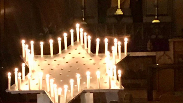 Church interior with lit candles and pews