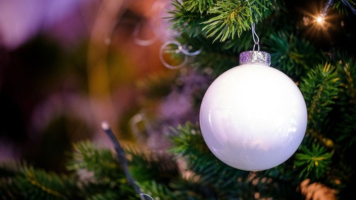 Weißer Christbaumschmuck an einem Tannenzweig