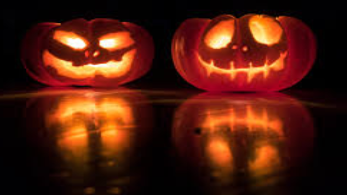 To halloweenly udskårne pumpker med glowende lygter indeni.