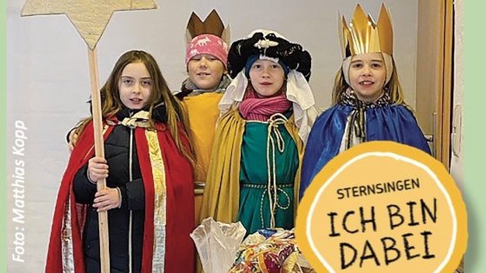 Vier Kinder in farbenfrohen Kostümen feiern Sternsingen mit dem Spruch "Ich bin dabei".