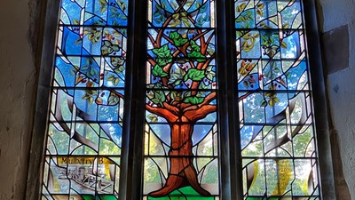 Stained glass window with tree design in building.