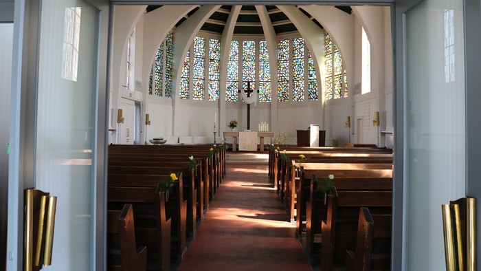 Die Kirche mit Holzgebäuden und buntem Glasfenster.