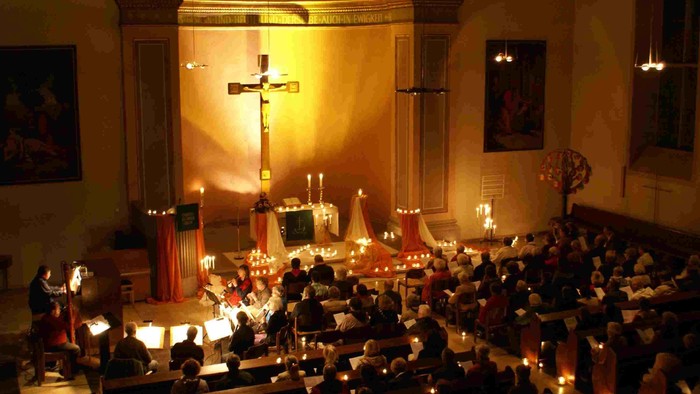 Eine Kirche mit vielen Kerzen und Menschen, die beten