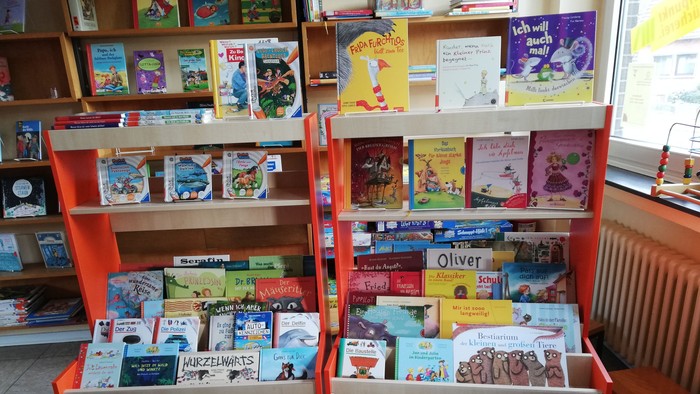 Bücherei mit vielen Kinderbüchern auf Regalen und Tischen