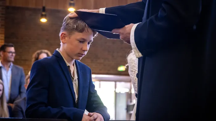 En ung kandidat modtager sin studenterhue fra en embedsmand under en officiel ceremoni.