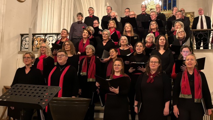 Stort kor, der poser sammen i en kirke.