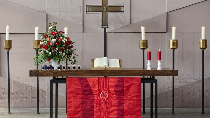 Kirchenaltar mit Kreuz, Kerzen und Blumen