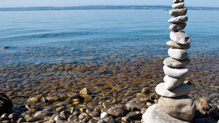Steine am Strand aufgetürmt, Meer und Himmel im Hintergrund