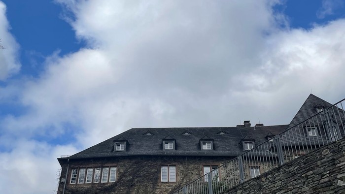 Steinernes Gebäude mit spitzen Fenstern und blauen Himmel