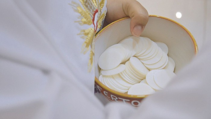 Hand greift in Schale mit weißen Keksen