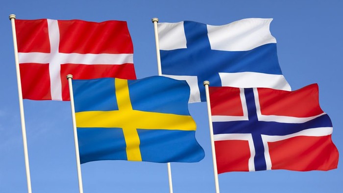 Fire nordiske flag på stang i blå himmel