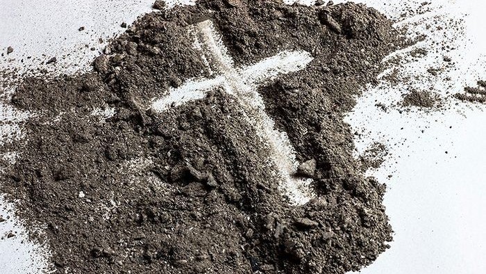 Cross drawn in dirt.