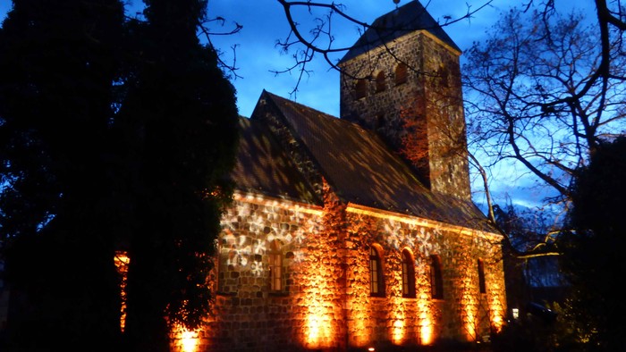 Eine Kirche aus Stein mit Beleuchtung bei Nacht
