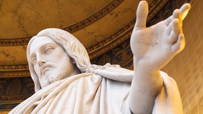 En marmorskulptur af en mand med udstrakt arm.