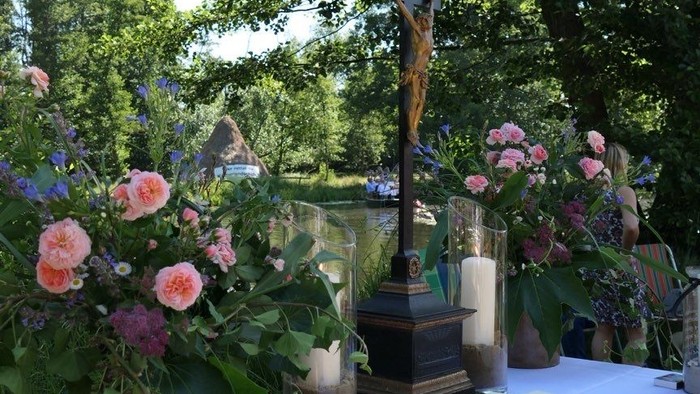 Ein Tisch mit Blumen und einem Buch unter Bäumen