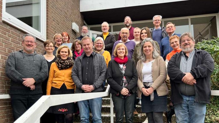 Eine Gruppe von Menschen posiert vor einem Gebäude