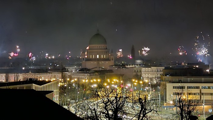 Feierliche Nachtansicht einer Stadt mit Feuerwerk und beleuchtetem Dom