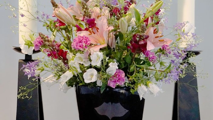 Ein Blumenstrauß in einer schwarzen Vase auf einem Tisch