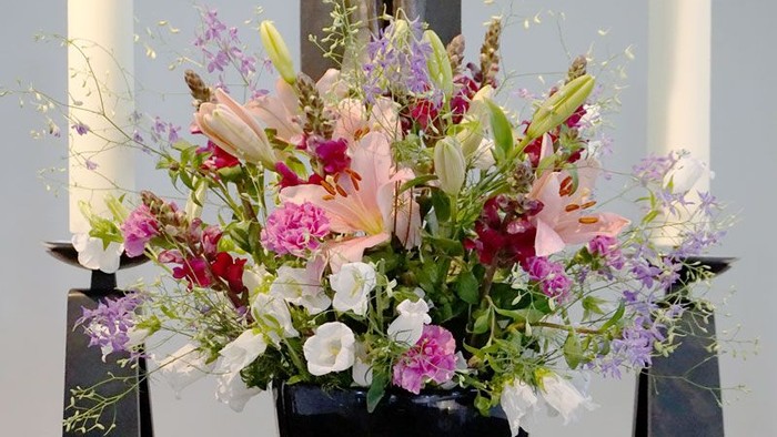 Ein Blumenstrauß in einer schwarzen Vase auf einem Tisch