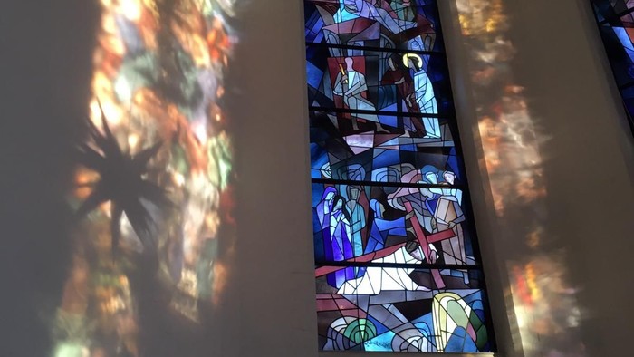 Buntes Kirchenfenster wirft bunte Schatten an die Wand