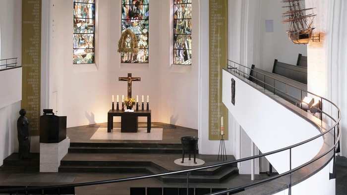 Die Kirche hat ein hohes Gewölbe, bunte Fenster und eine Schiffsmodell-Ausstellung.