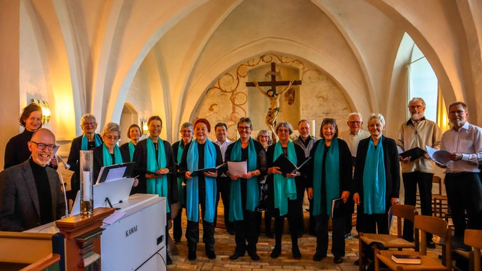 En kor med blå kapper synger i en kirke