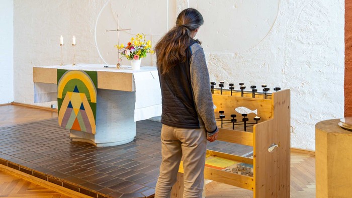 Frau beugt sich über einen Tisch mit Flaschen in einem hellen Raum