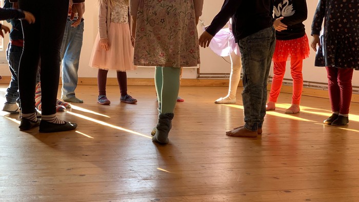 Kinder tanzen in einer Reihe auf einem Holzboden