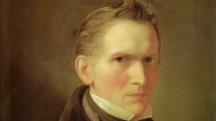 Ein junger Mann mit blonden Haaren und dunkler Kleidung wird porträtiert.