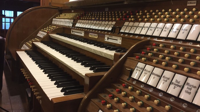Ein großes Kirchenorgel mit zahlreichen Registern und Tasten.